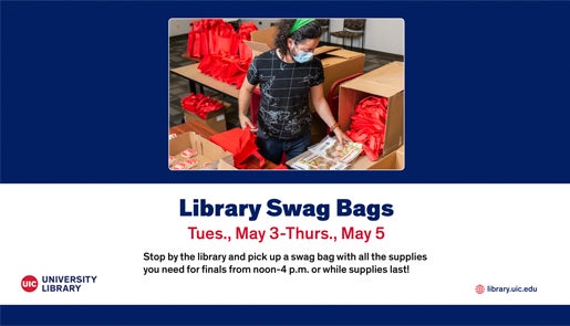 Student standing behind a table while filling red swag bags with coloring books and other materials.