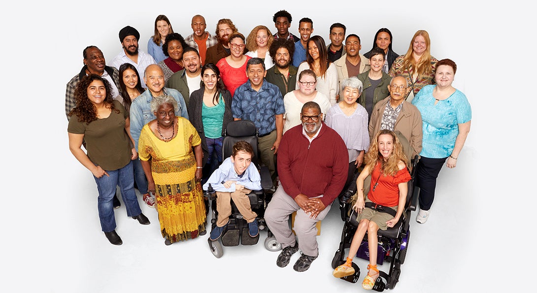 A view from above of a large diverse group of people standing and sitting in wheelchairs.